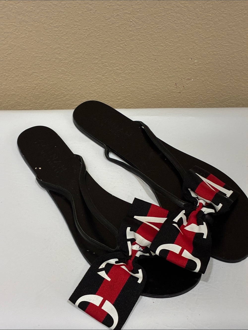 Aminah Abdul Jillil Black Slide Sandals with Red & White Bow Accent